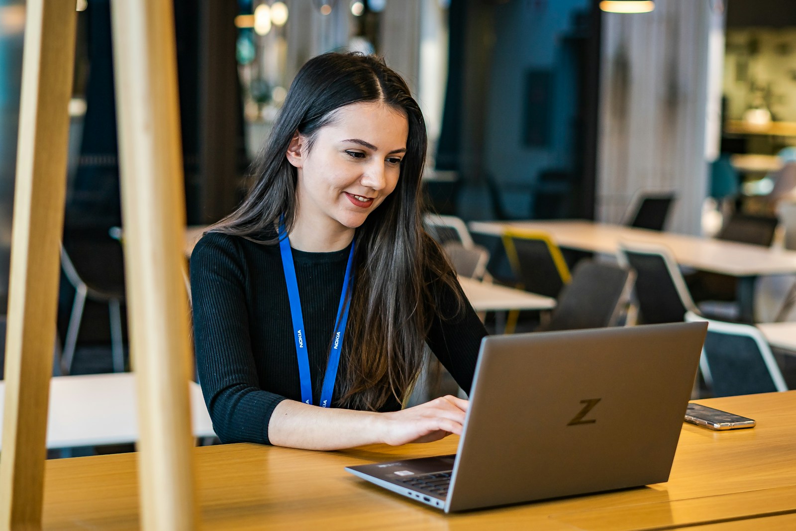 a woman sitting at a table using a laptop computer